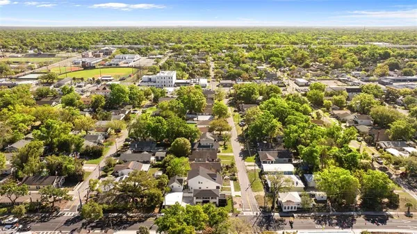 an aerial view of residential houses with outdoor space and trees