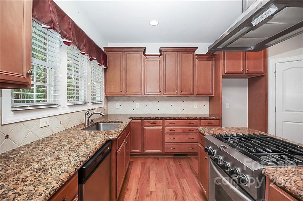 4080 Crepe Ridge Drive Denver, NC 28037 - Photo 13 of 34 a kitchen with granite countertop a sink stove and refrigerator