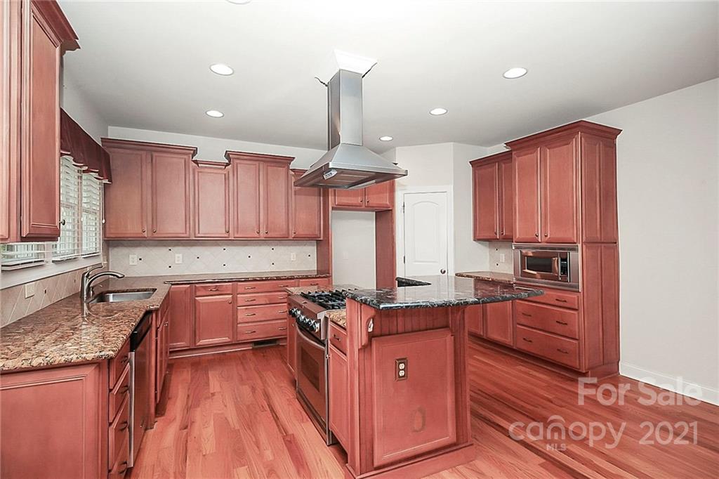 4080 Crepe Ridge Drive Denver, NC 28037 - Photo 15 of 34 a kitchen with granite countertop wooden cabinets and a stove