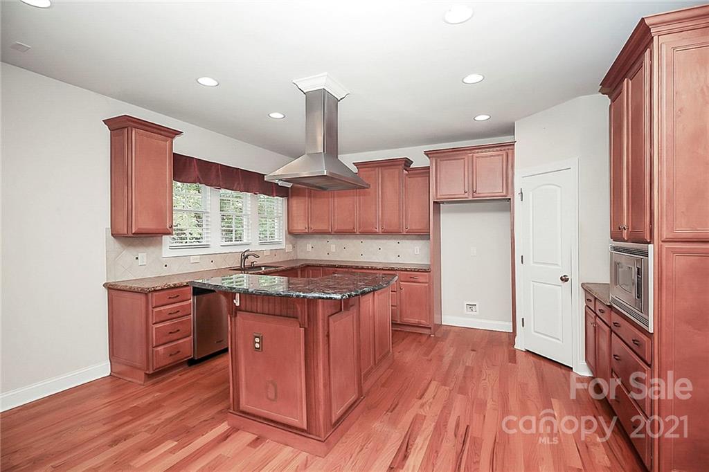 4080 Crepe Ridge Drive Denver, NC 28037 - Photo 16 of 34 a large kitchen with stainless steel appliances granite countertop a stove a sink dishwasher and a refrigerator with wooden floor