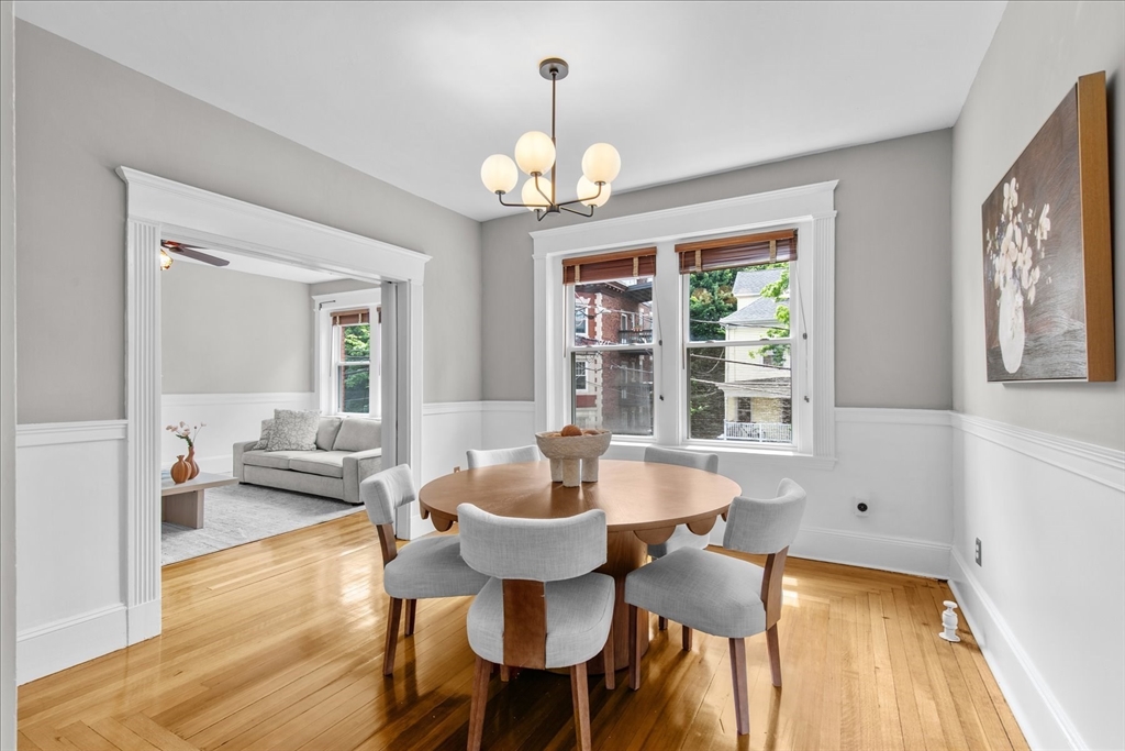 9 Verndale Street, Unit 2 Brookline, MA 02446 - Photo 6 of 39 a dining room with wooden floor a chandelier a glass table and chairs