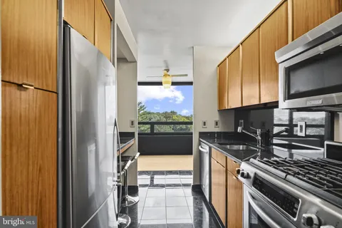 a kitchen with stainless steel appliances granite countertop a refrigerator and a stove