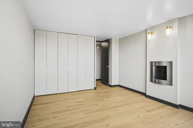 a view of an empty room with wooden floor and entryway
