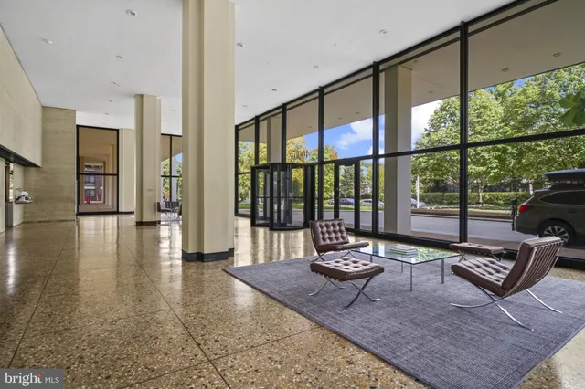 a living room with furniture and a floor to ceiling window