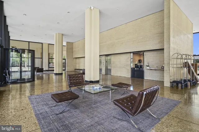 a living room with furniture and a floor to ceiling window