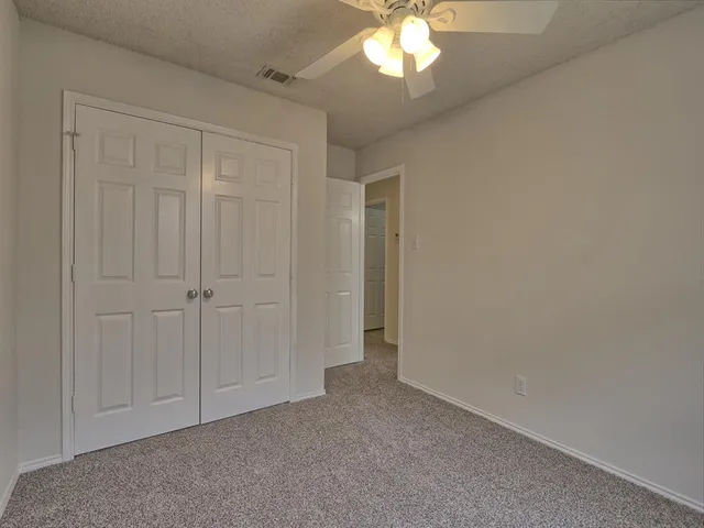 en empty room with windows and ceiling fan