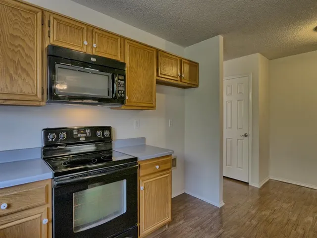 a kitchen with stainless steel appliances a stove a microwave sink and cabinets