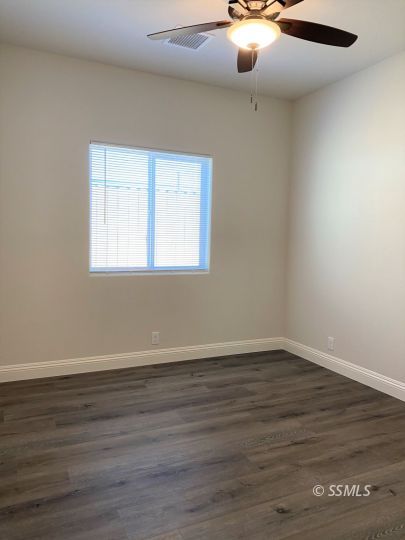 1517 Mayo Street Ridgecrest, CA 93555 - Photo 19 of 32 a view of an empty room with wooden floor and a window