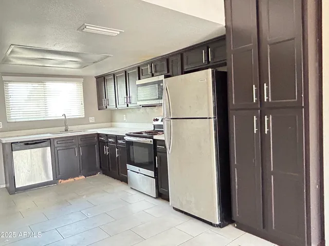 a kitchen with a refrigerator sink and cabinets