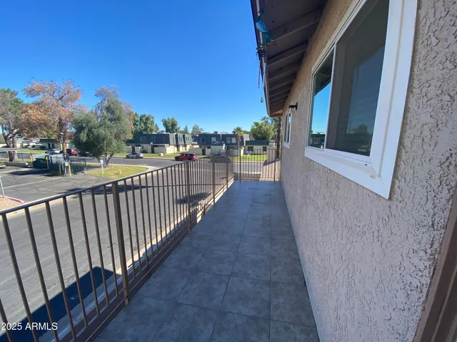 a view of a balcony with wooden floor and fence