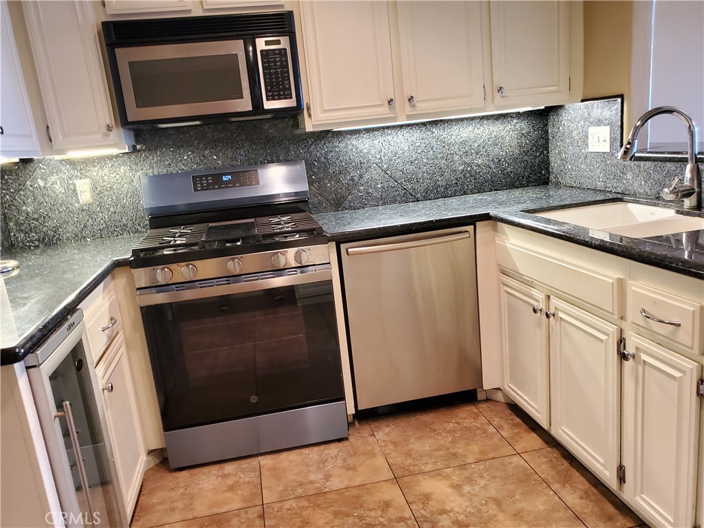 27795 Rota Mission Viejo, CA 92692 - Photo 14 of 27 a kitchen with granite countertop white cabinets and stainless steel appliances