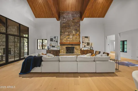 a living room with fireplace furniture and a large window