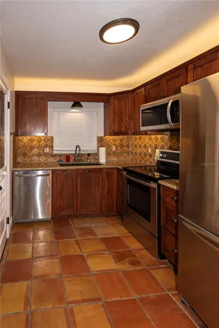 a kitchen with stainless steel appliances granite countertop a refrigerator and a sink