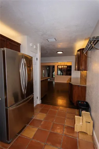 a view of a refrigerator in kitchen and windows