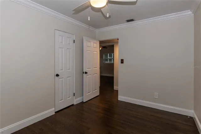 a view of an empty room with wooden floor