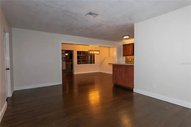 a view of a big room with wooden floor and windows