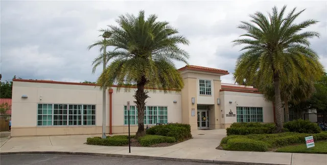 a view of a house with a yard and palm trees
