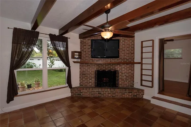 a view of a livingroom with furniture fireplace and window