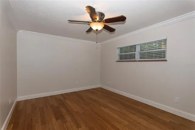 a view of wooden floor and a chandelier fan in a room