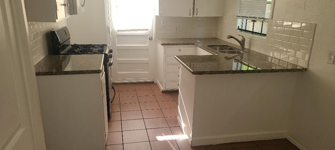4423 Knotty Oaks Trail Houston, TX 77045 - Photo 4 of 12 a kitchen with a refrigerator and a stove