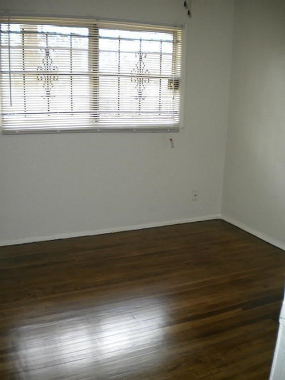 4423 Knotty Oaks Trail Houston, TX 77045 - Photo 10 of 12 an empty room with wooden floor and windows