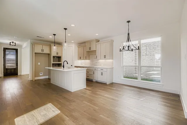 a large kitchen with kitchen island a sink stainless steel appliances and cabinets