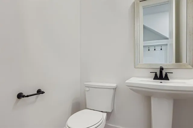 a bathroom with a sink toilet and mirror