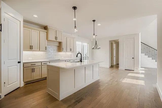 a large kitchen with kitchen island a sink a center island stainless steel appliances and a window