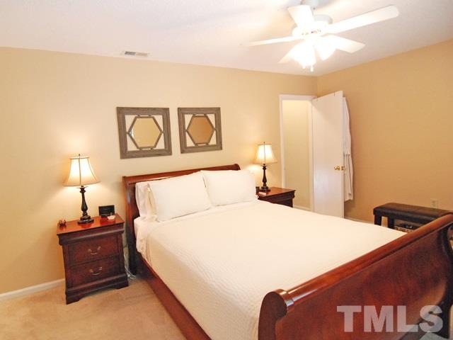 7827 Falcon Rest Circle Raleigh, NC 27615 - Photo 14 of 24 a bedroom with a bed and a lamp