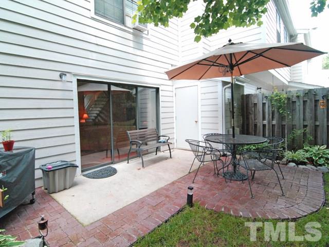 7827 Falcon Rest Circle Raleigh, NC 27615 - Photo 22 of 24 a view of a patio with table and chairs under an umbrella
