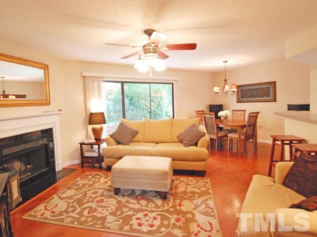 7827 Falcon Rest Circle Raleigh, NC 27615 - Photo 5 of 24 a living room with furniture a fireplace and a flat screen tv