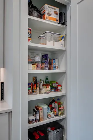 a cabinet with granite countertop lots of different kinds of food