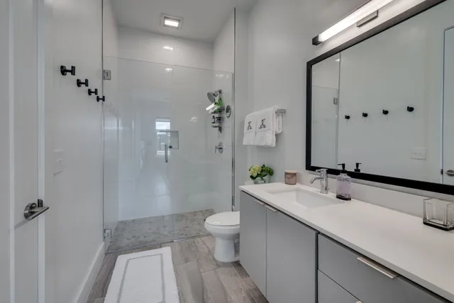 a bathroom with a sink a toilet and shower