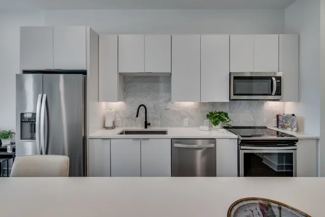 a kitchen with stainless steel appliances a stove a sink a microwave and refrigerator