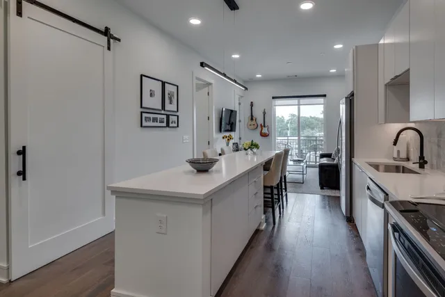 a kitchen with kitchen island a sink stove and refrigerator
