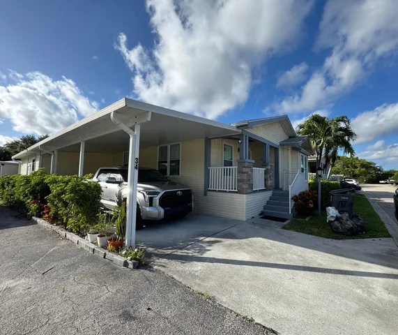 a front view of a house with a yard and potted plants