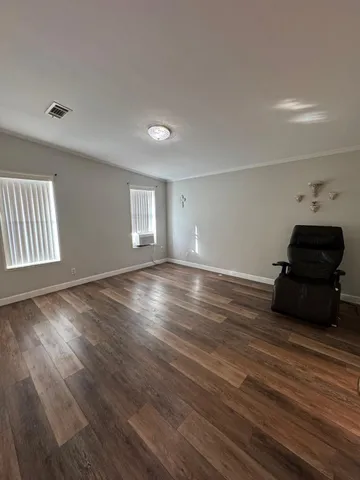 a view of a livingroom with wooden floor and window