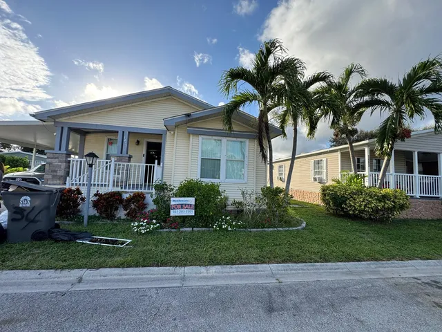 a front view of a house with a garden and plants
