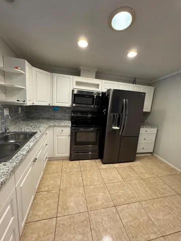 a kitchen with stainless steel appliances granite countertop a sink and cabinets
