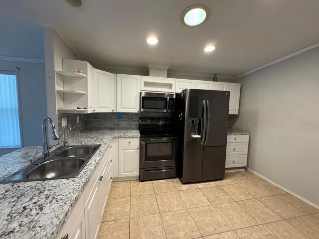 a kitchen with refrigerator and cabinets
