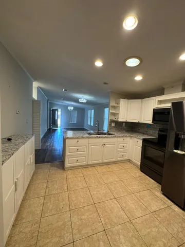 a large kitchen with a large counter top cabinets and stainless steel appliances