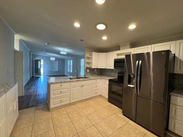 a kitchen with granite countertop a refrigerator and a sink