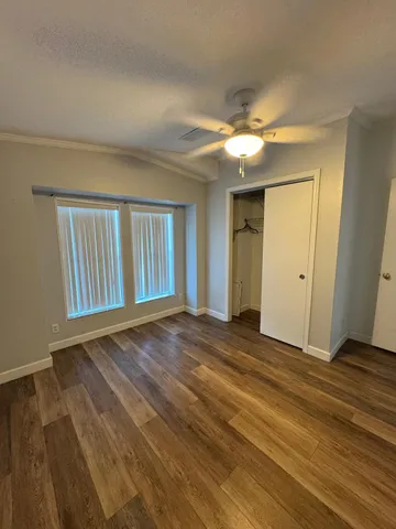 a view of an empty room with window and wooden floor