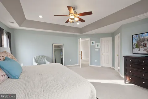 a spacious bedroom with a bed and a chandelier