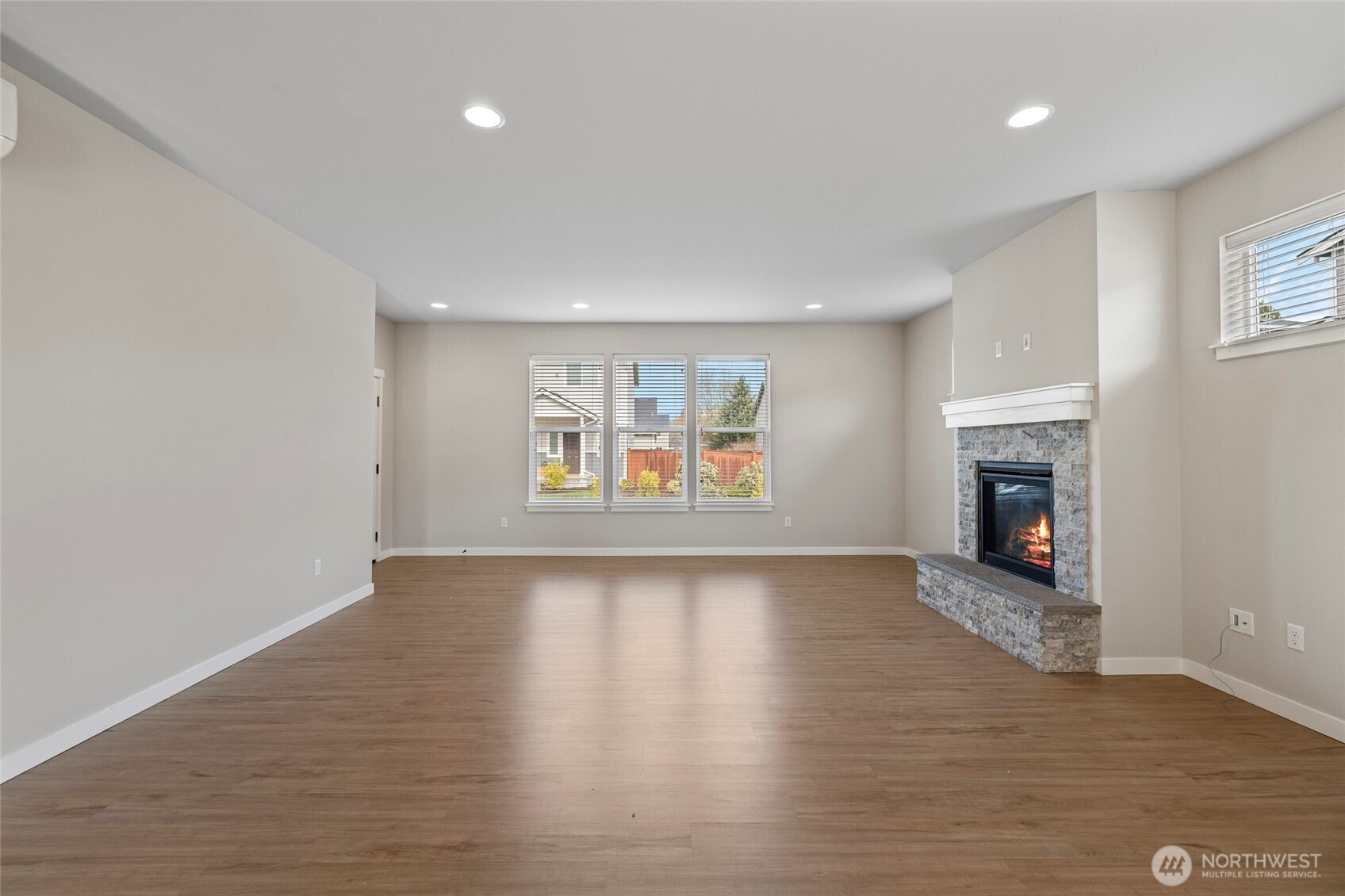 122 North Trl Road Sedro-Woolley, WA 98284 - Photo 8 of 40 an empty room with wooden floor fireplace and windows