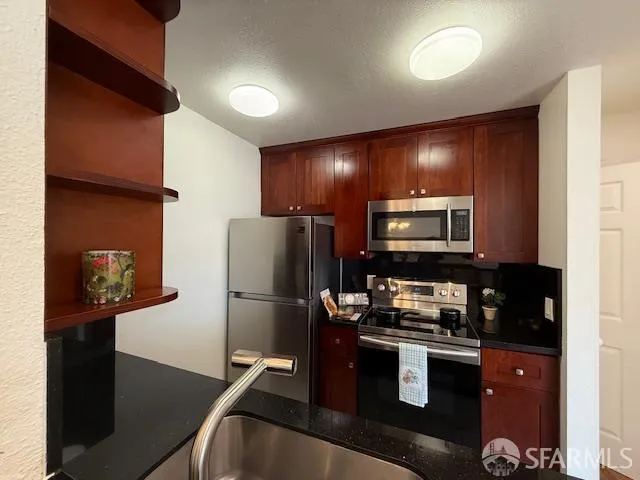 a kitchen with a refrigerator and a stove top oven