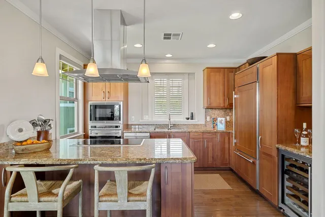 a kitchen with stainless steel appliances granite countertop a sink and a refrigerator