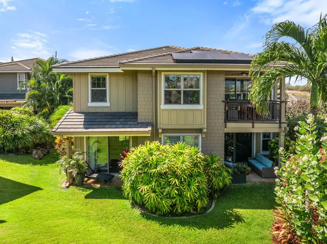 a front view of a house with a garden and trees