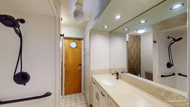 a bathroom with a granite countertop sink a toilet and shower