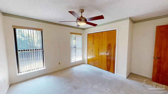 a view of a livingroom with a ceiling fan and window